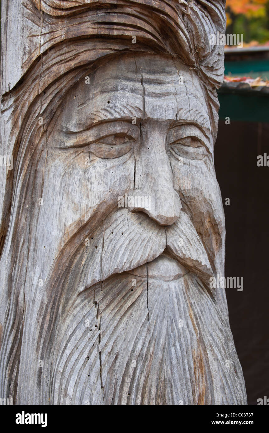 Alter Mann mit langem Bart Holzschnitzerei in einen alten Baum Silber Geist Mann des Waldes zeigen Alter und ruhige Weisheit. Stockfoto