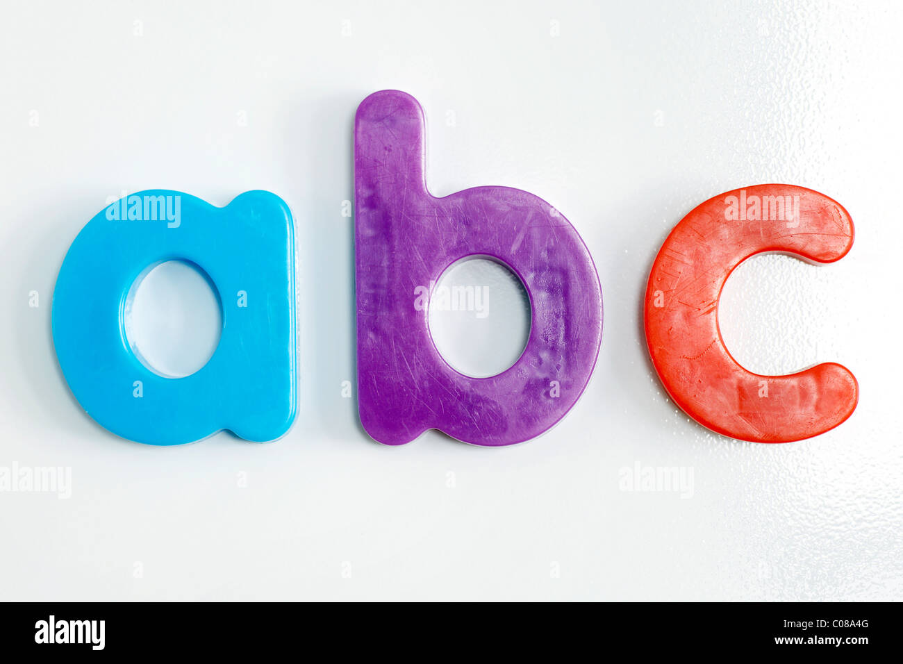 Kühlschrank-Magnet: bunte Kunststoff Alphabet Buchstaben auf strukturierte weiße Kühlschrank. Stockfoto