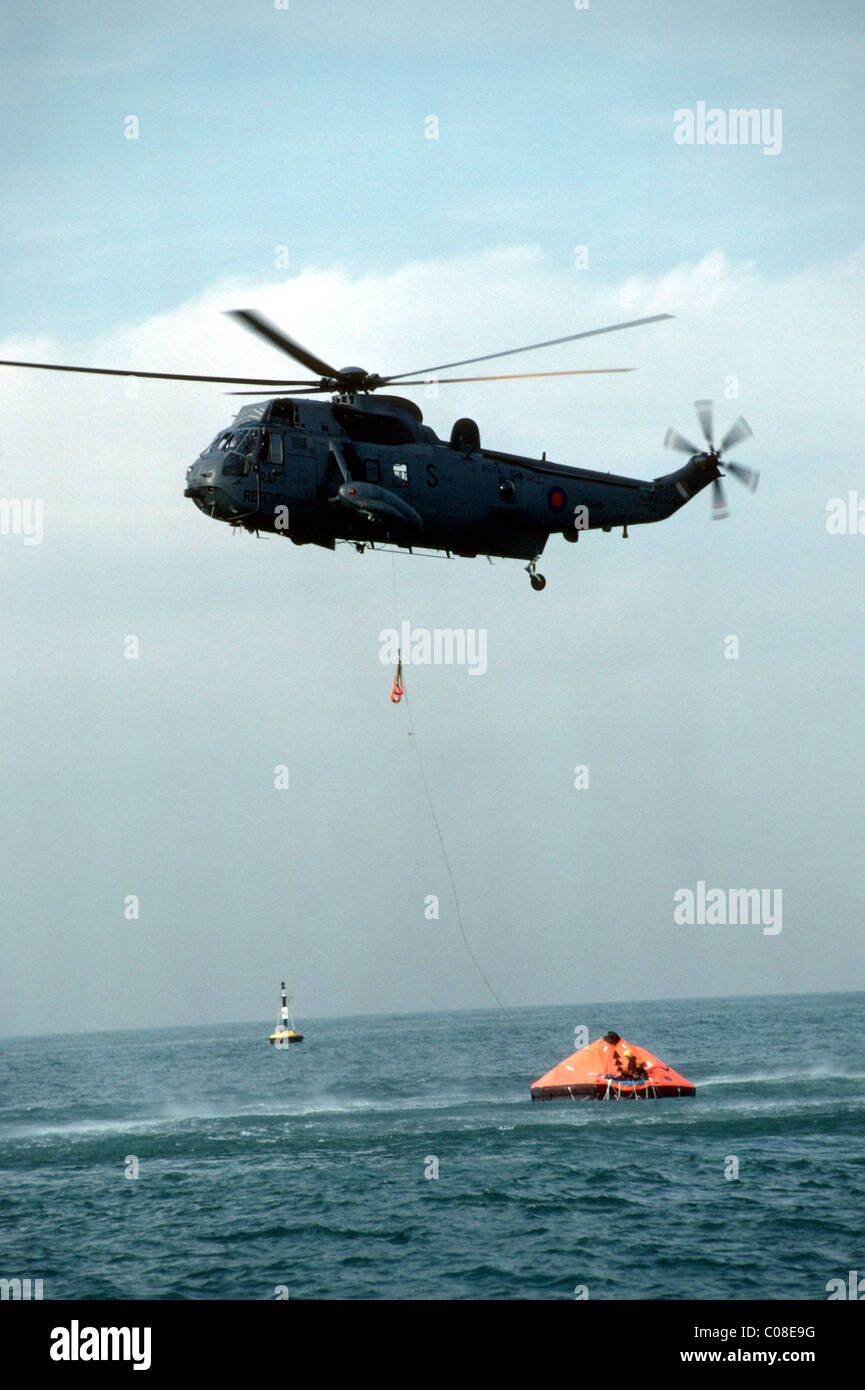 Hubschrauber kommen, um die Rettung der Männer in einem Schlauchboot auf dem Meer Stockfoto