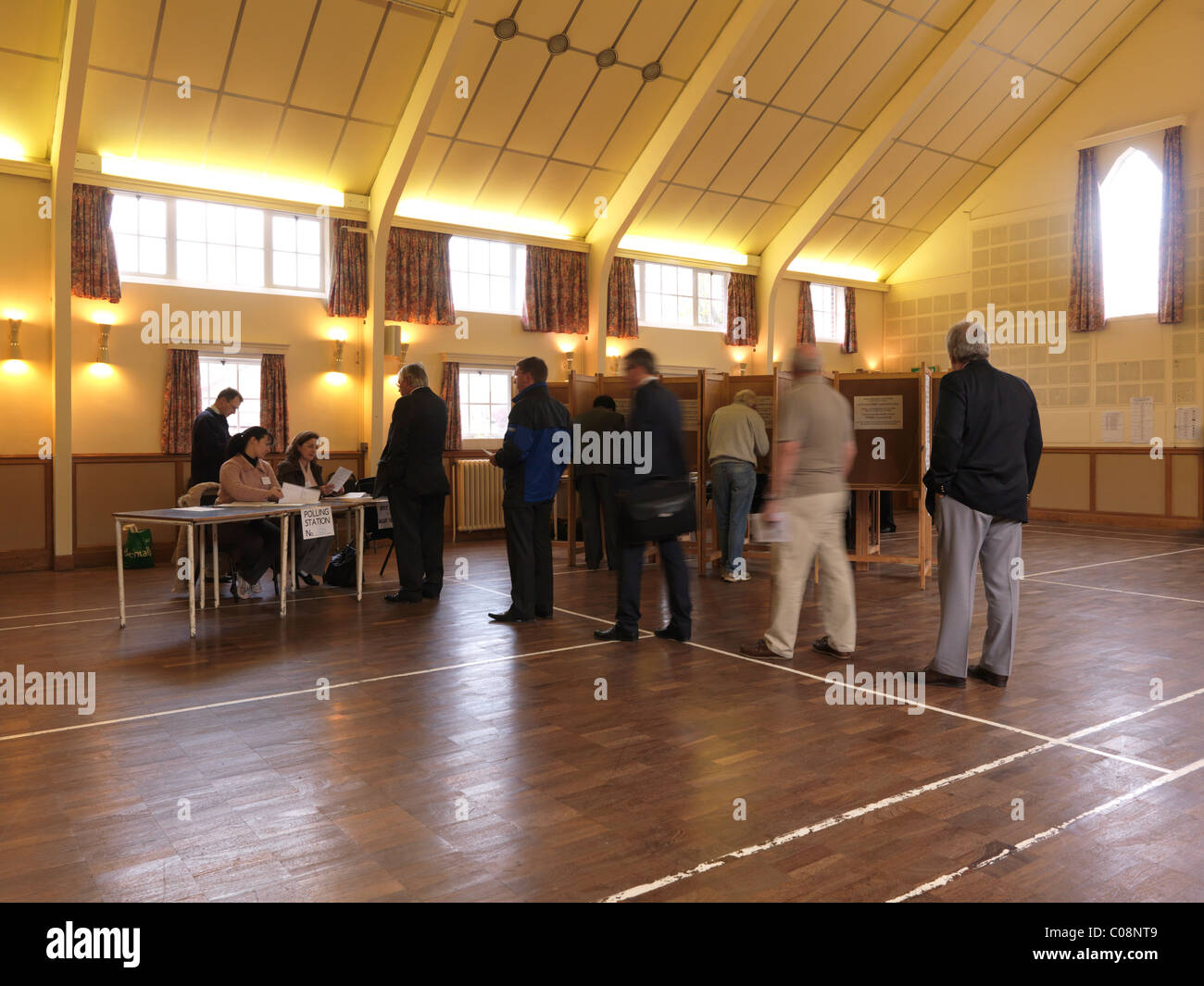 Menschen, die Schlange, bis um rutscht auf allgemeine Wahl Mai 2010 im Kirchgemeindehaus England Stimmen bekommen Stockfoto