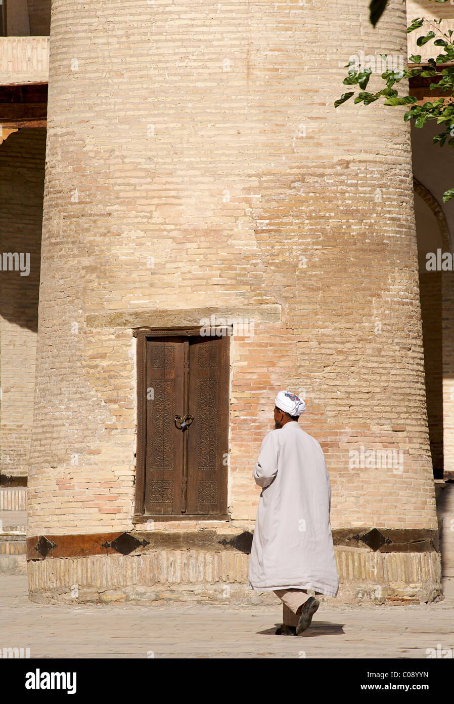 Usbekischer Mann zu Fuß vorbei an Basis des Minaretts, Bakhautin Naqshband Mausoleum in der Nähe von Buchara, Usbekistan Stockfoto