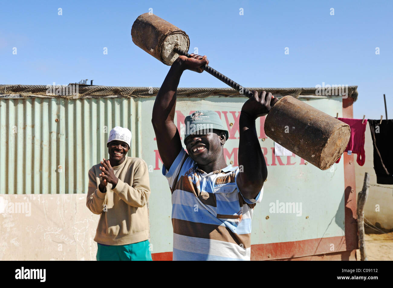 Schwarzer Athlet Traning mit selbstgemachten Gewichte in Mondesa Township, Swakopmund Stadt, Namibia, Afrika Stockfoto