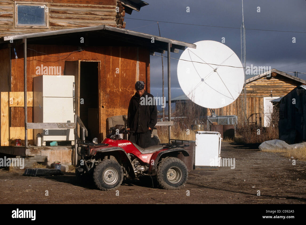 Native Mann steht neben einem ATV auf ein Herbsttag in Arctic Village, Arktis Alaska Stockfoto