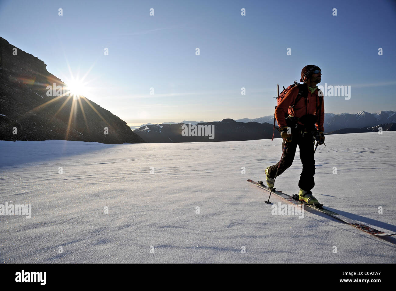 Backcountry Skifahrer macht am frühen Morgen Aufstieg von der Nordseite des Mount Chamberlin, Brooks Range ANWR, Arktis Alaska, Sommer Stockfoto