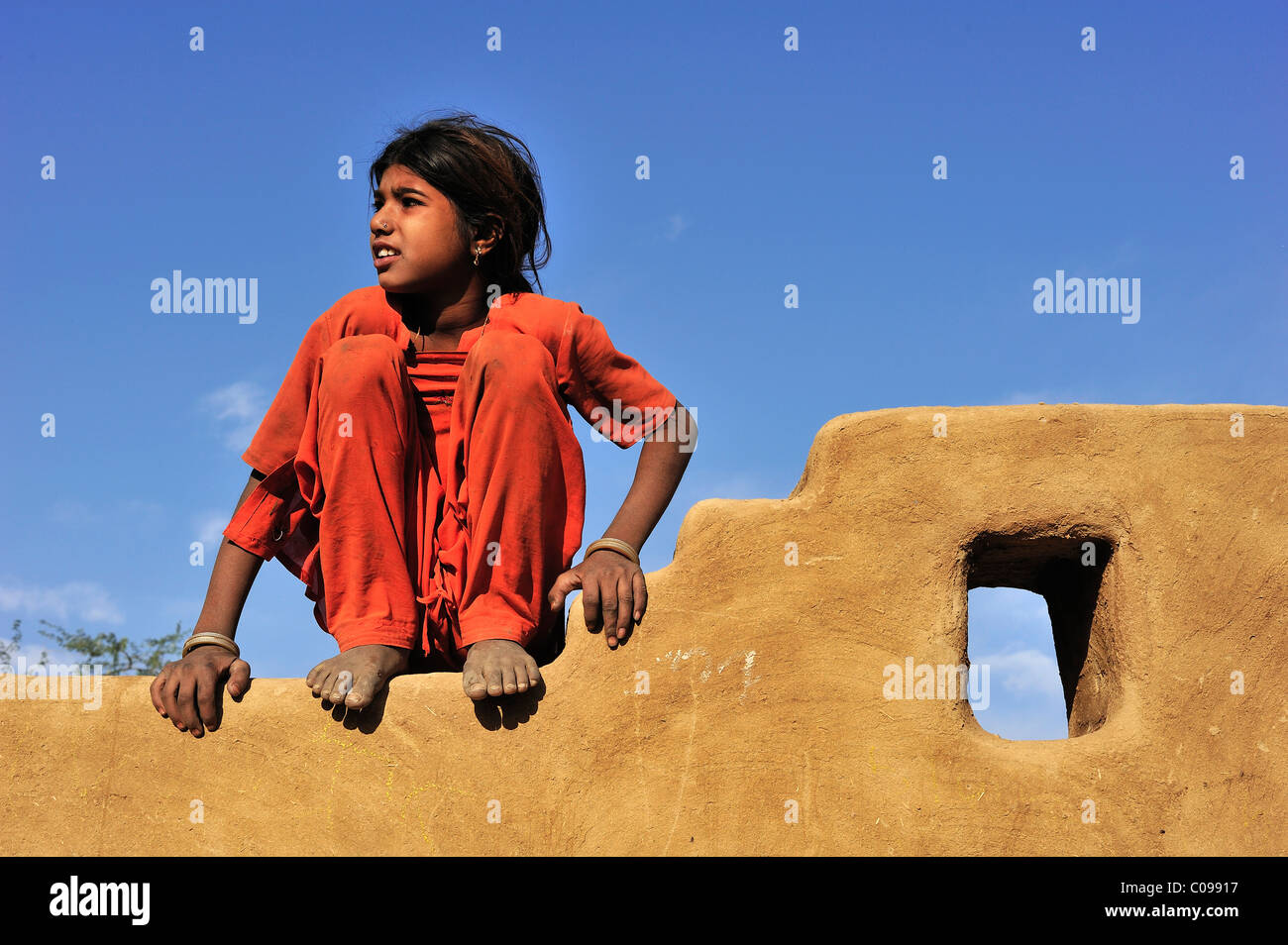 Kleines Mädchen sitzt auf einer Mauer, Thar-Wüste, Rajasthan, Indien, Asien Stockfoto