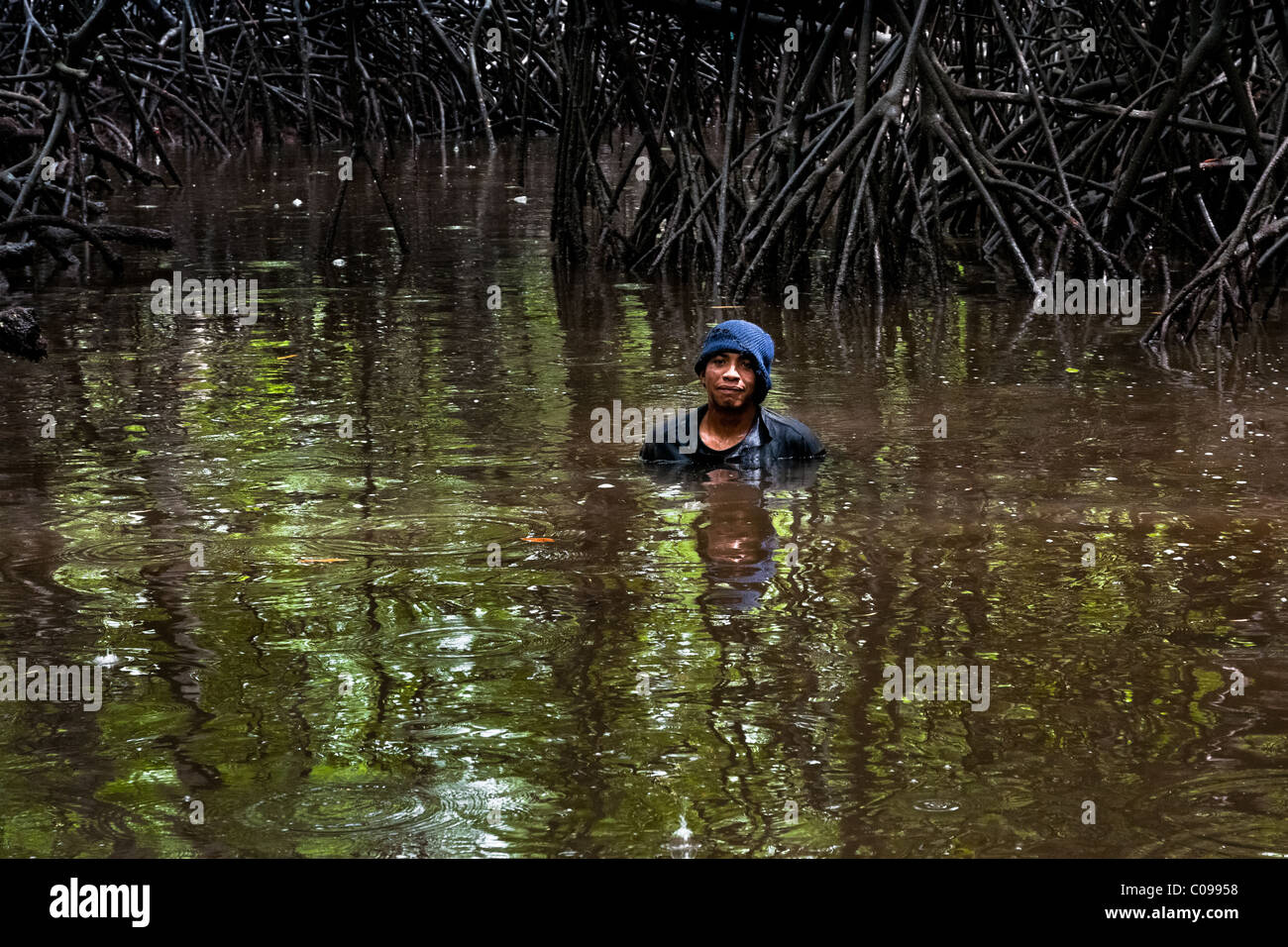 Eine kolumbianische junge steht im Wasser der einen flachen Kanal in die Mangrovensümpfe an der Pazifikküste, Kolumbien. Stockfoto