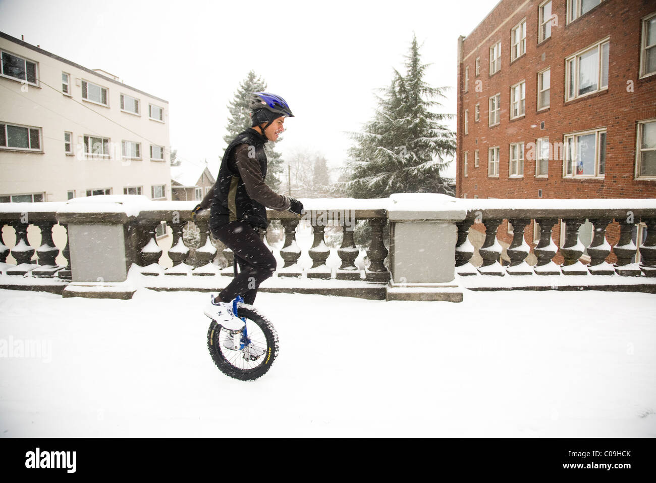 Ein Mann reitet auf seinem Einrad an einem verschneiten Tag in Seattle. Stockfoto