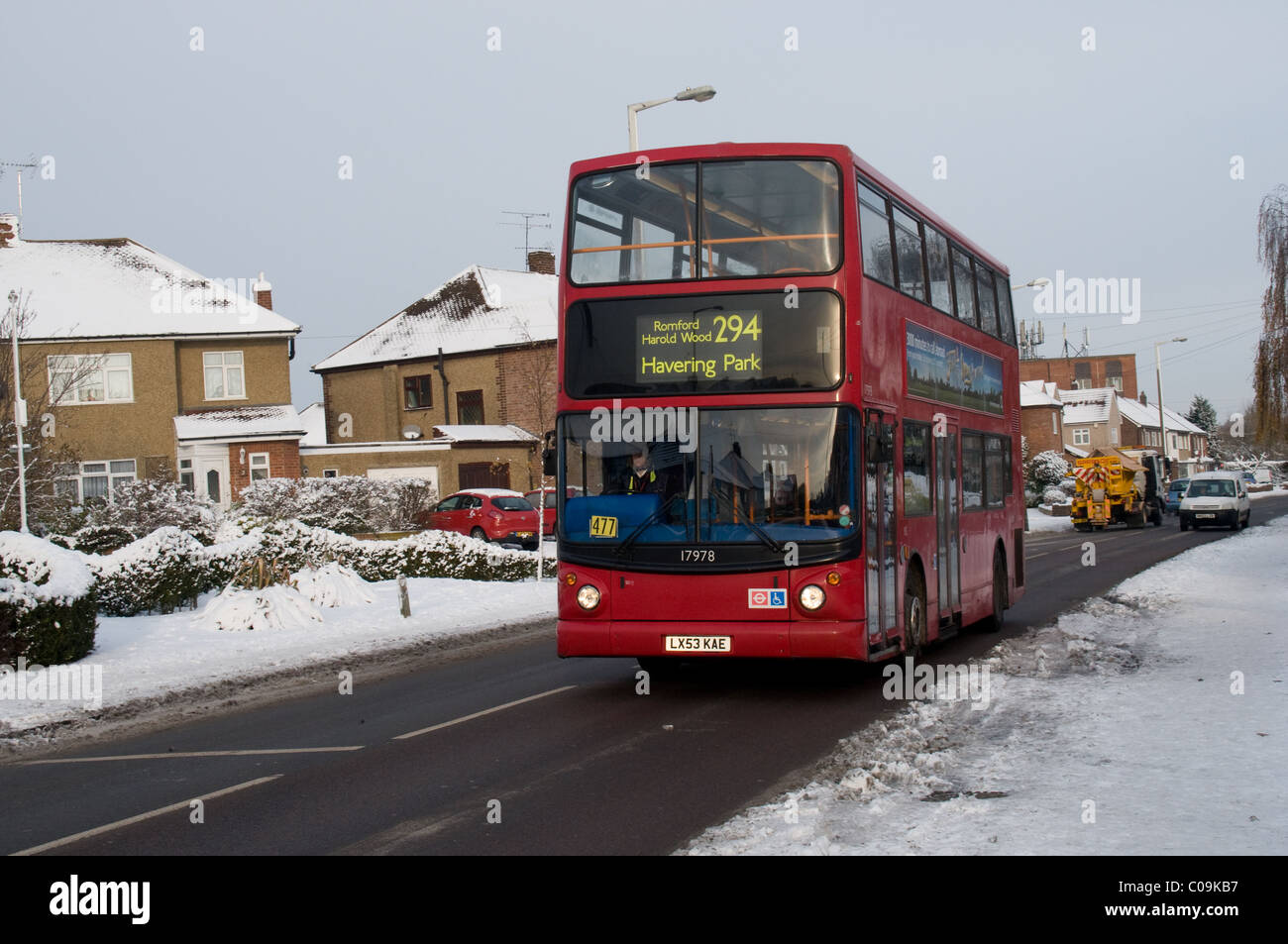 Ein Postkutsche London Bus fährt entlang einer frisch zusammengebissenen Straße in Harold, Romford Essex. Der Bus ist ein Transbus Trident. Stockfoto