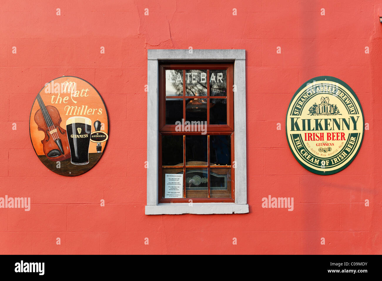 Außenwand einer Kneipe, Matt Miller, Embleme der Guinness Bier und St. Francis Abbey Brauerei, Kilkenny, Grafschaft Kilkenny, Irland Stockfoto