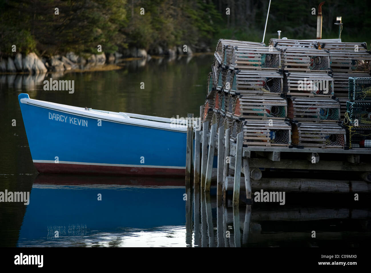 Angelboot/Fischerboot vor Anker neben einem Stapel von Hummerfallen auf Clam Harbour, Nova Scotia, Kanada. Stockfoto