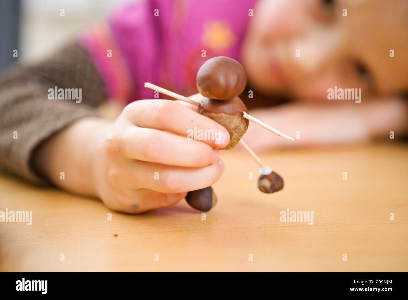 Ein Mädchen spielen mit Kastanien Stockfoto