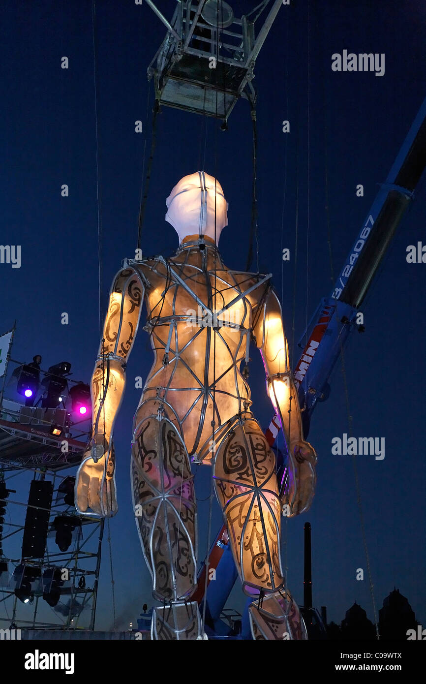 Riesige beleuchtete Figur an Seilen zu Fuß durch das Publikum, globale Rheingold, Open-Air-Theater von La Fura Dels Baus Stockfoto