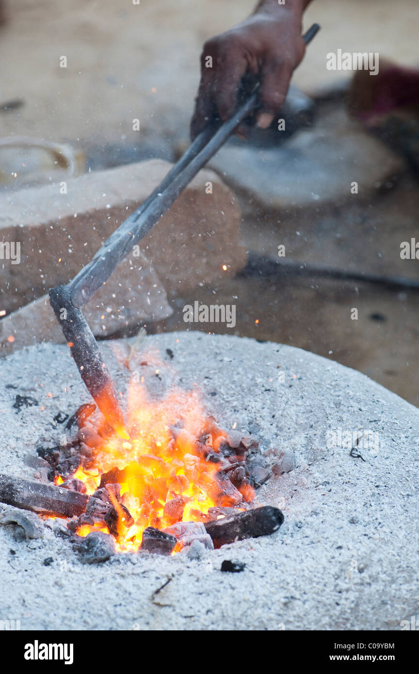 Inder schmieden Metall ax Köpfe für die Aufspaltung von Stein in der Straße Ofen. Andhra Pradesh, Indien Stockfoto