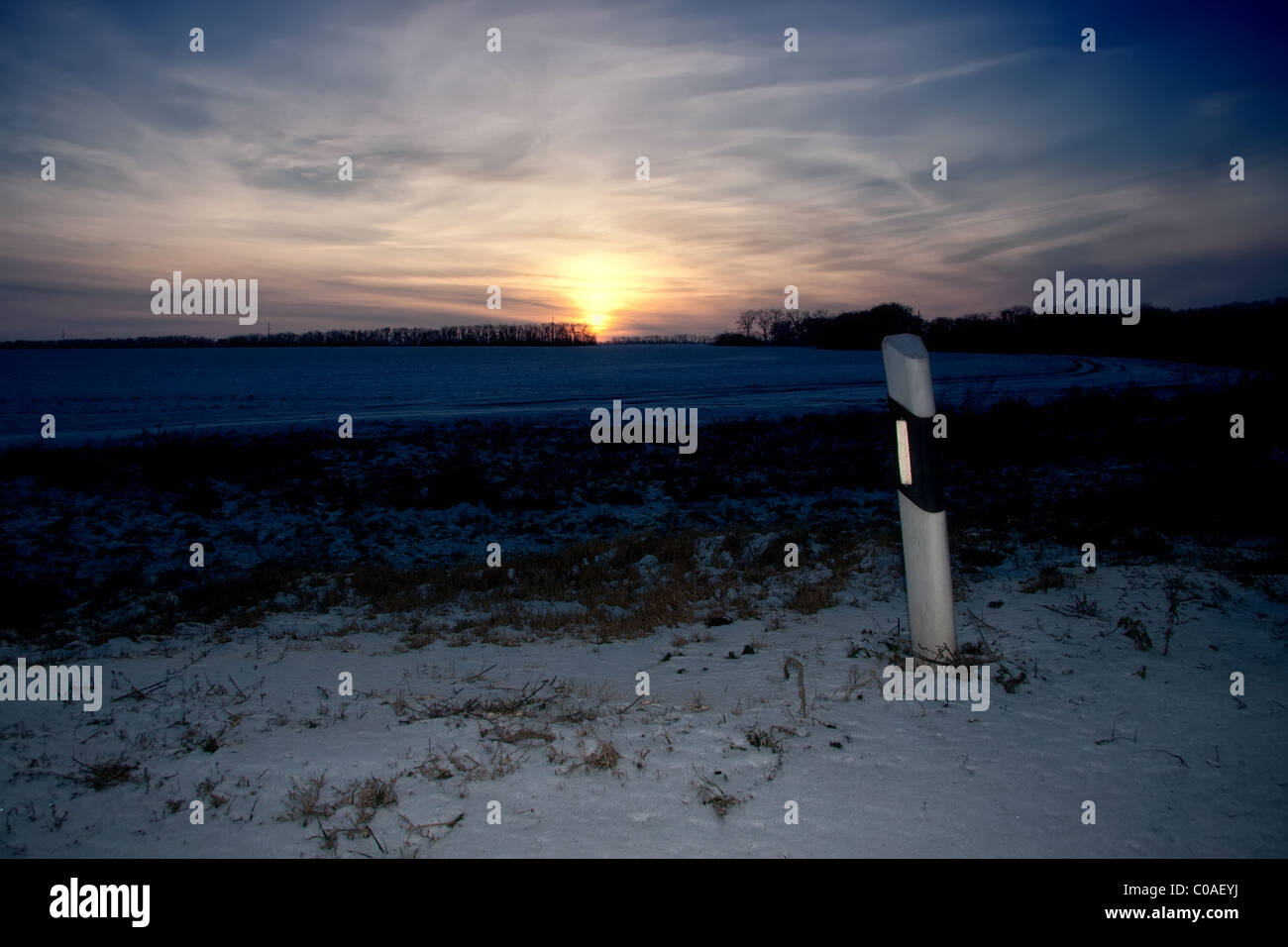 Einsame Pol im verschneiten Feld Stockfoto