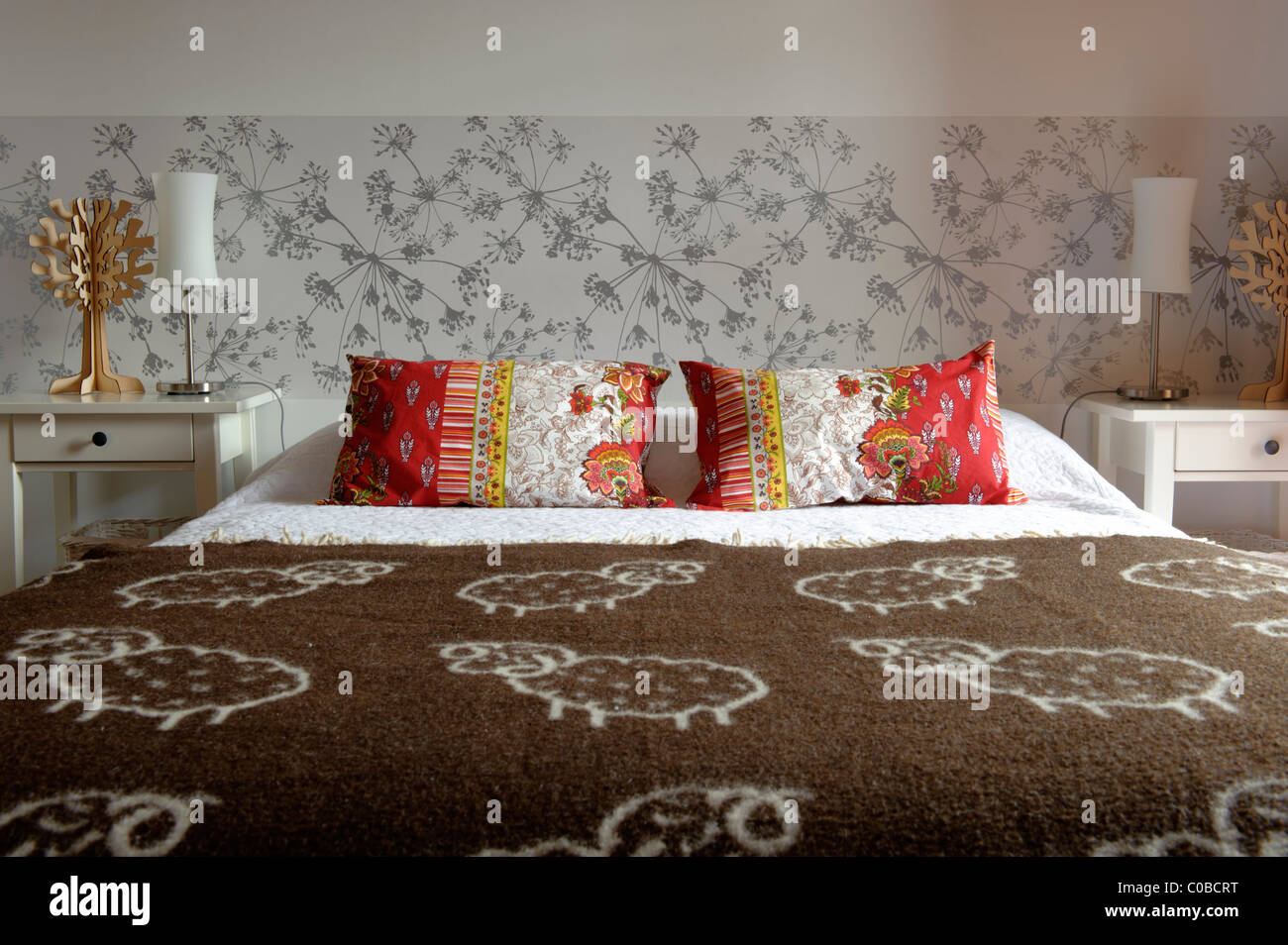 Schlafzimmer-Doppelbett mit Nachttischen und Lampen Stockfoto