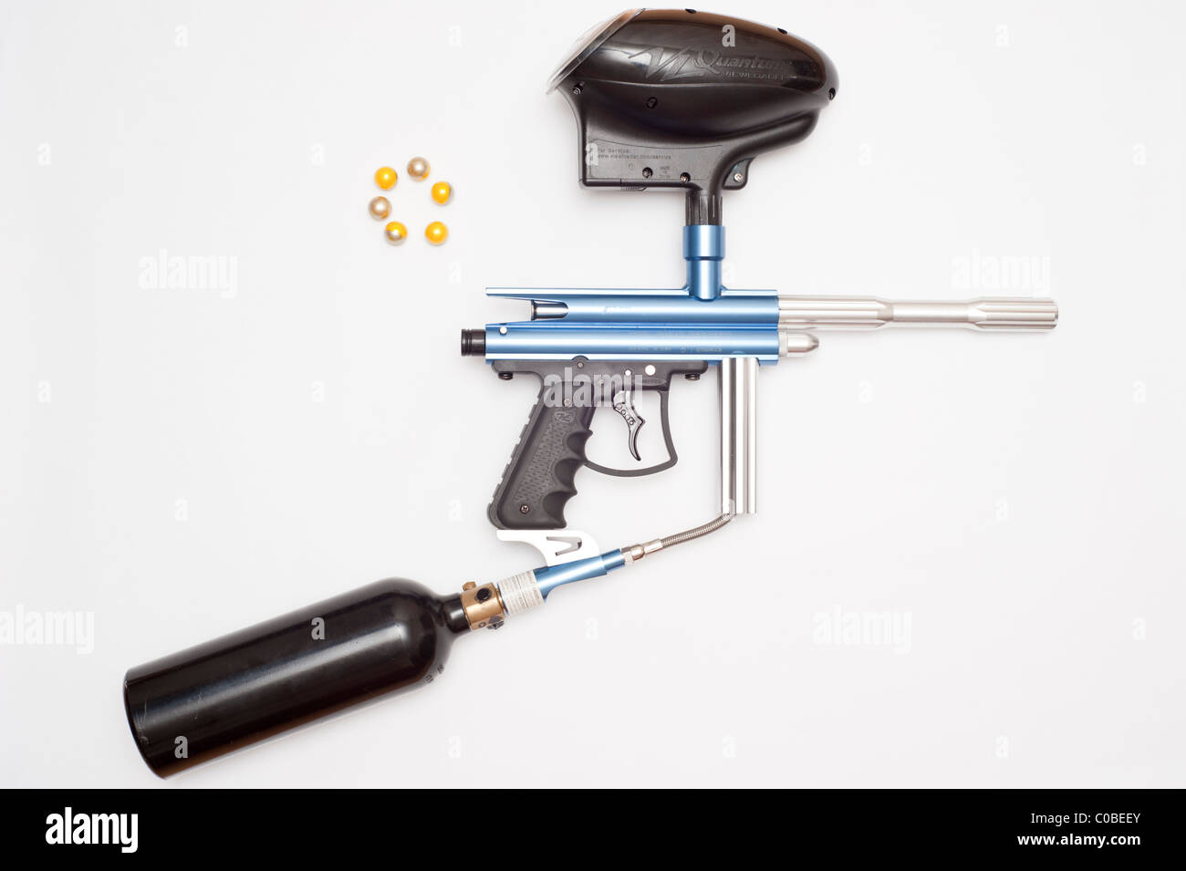 Ein Paintball-Gewehr mit Gas-Kanister und Paintballs Munition auf weißem Hintergrund Stockfoto