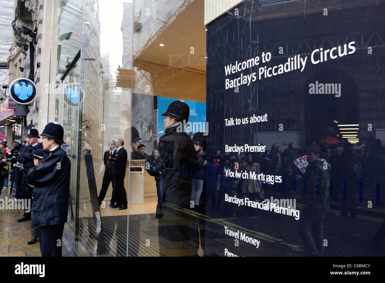 Piccadilly Circus-Zweig der Barclays geschlossen und bewacht von der Polizei, wie Demonstranten auf der anderen Straßenseite sammeln Stockfoto