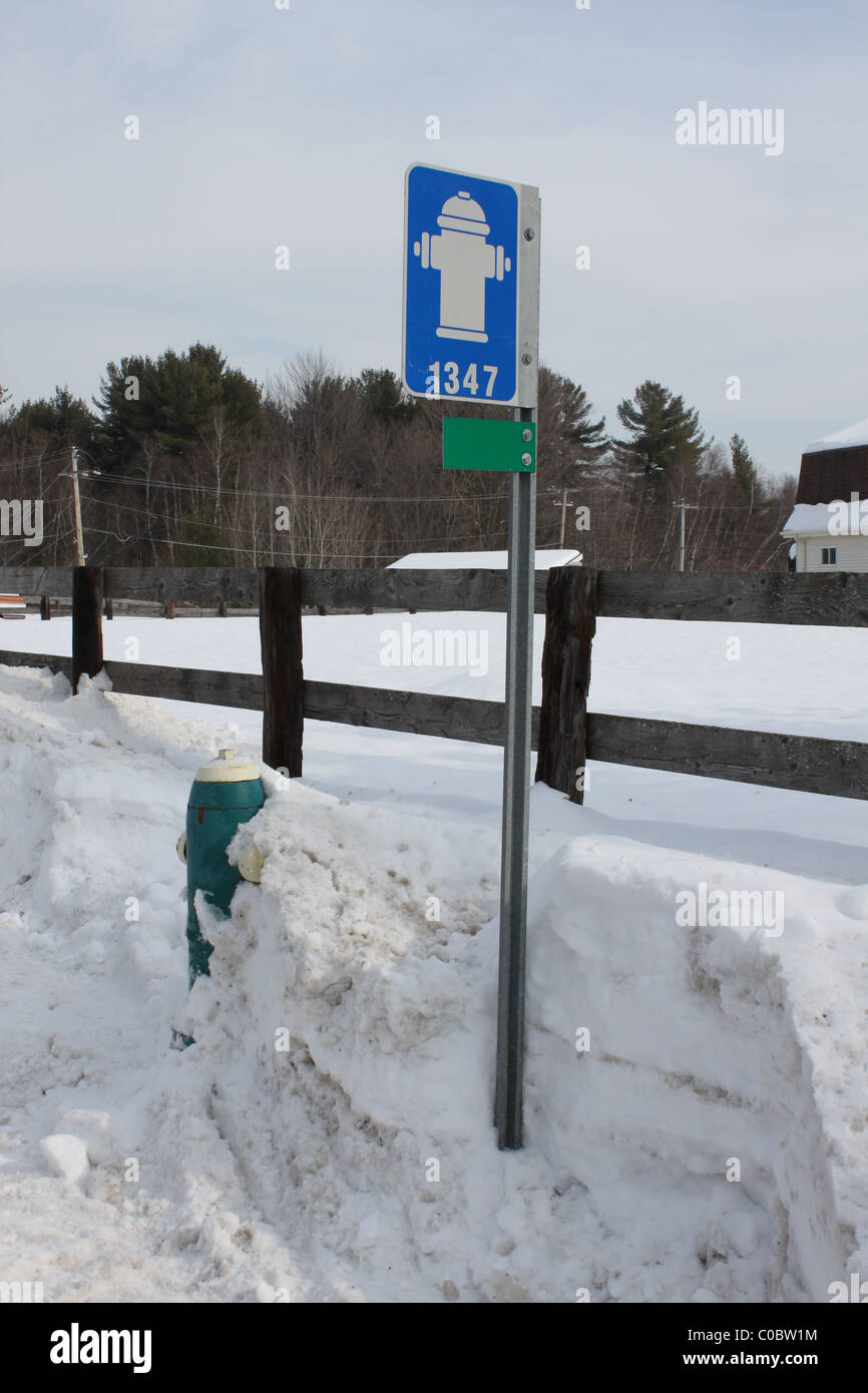 Hydranten und Straßenschild mit Schnee bedeckt Stockfoto