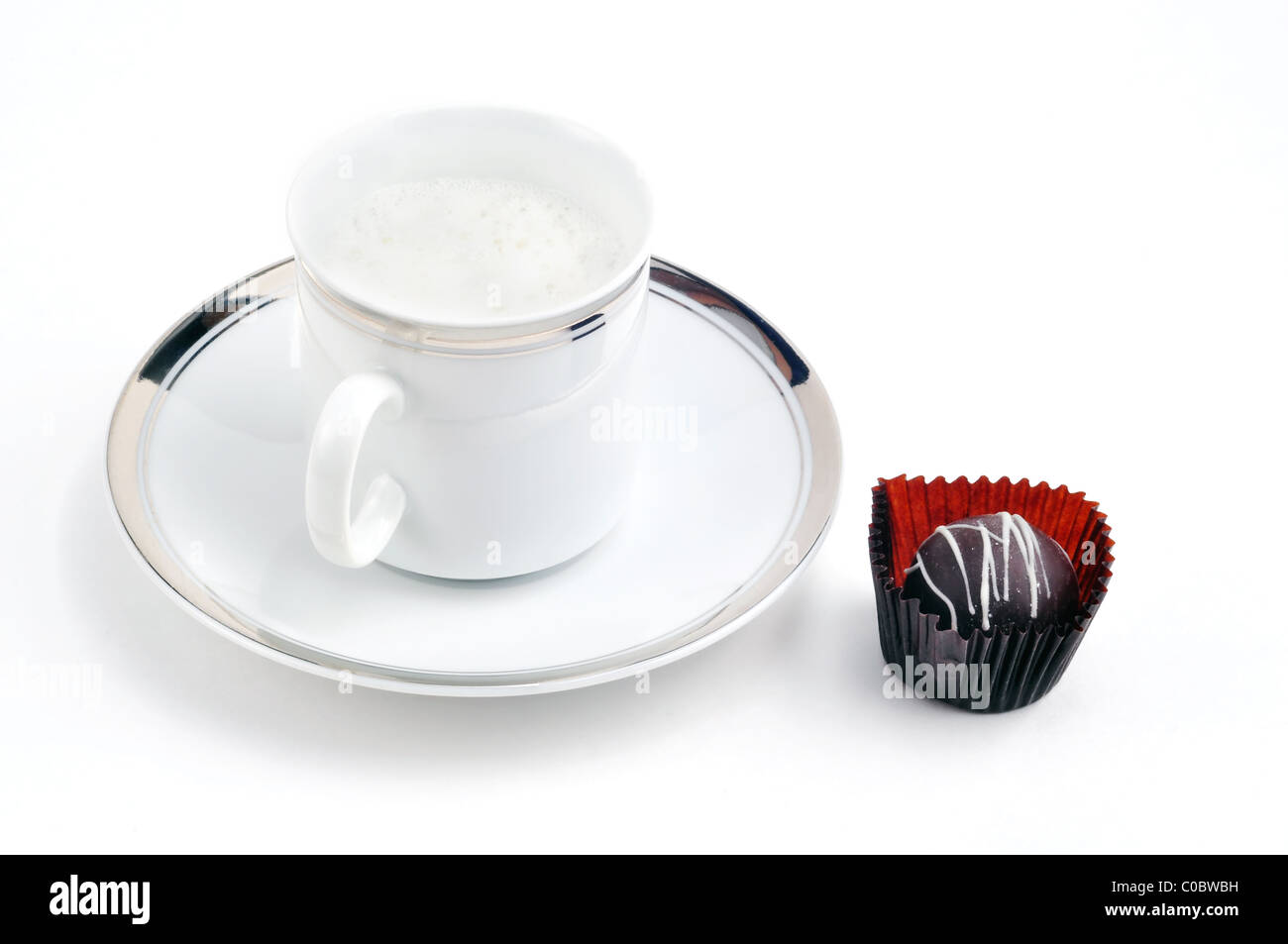 Am Nachmittag Genuss: Cappucino Kaffee oder Latte im fancy gold trim Tasse und Untertasse mit Schokolade serviert. Stockfoto