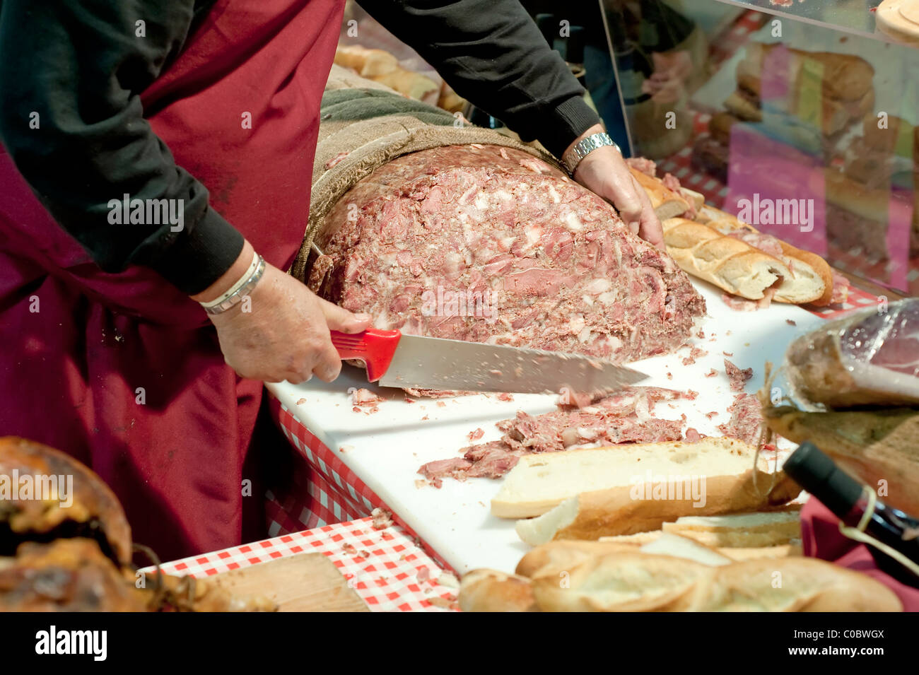 Metzger aufschneiden Coppa di Testa, eine typische Wurstwaren Produkt, hergestellt aus dem mageren Fleisch Futter des Schweins Kopf, Wangen und Muskeln Stockfoto