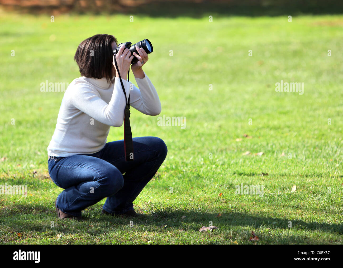 Hübsche Frau mit Kamera im freien hocken Stockfoto