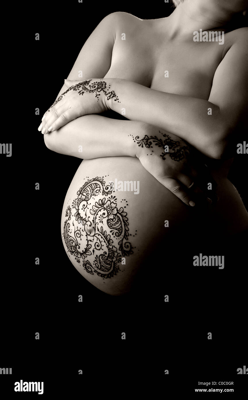 Ein b&w Foto von Henna auf Hände und Bauch einer schwangeren Frau angewendet. Stockfoto