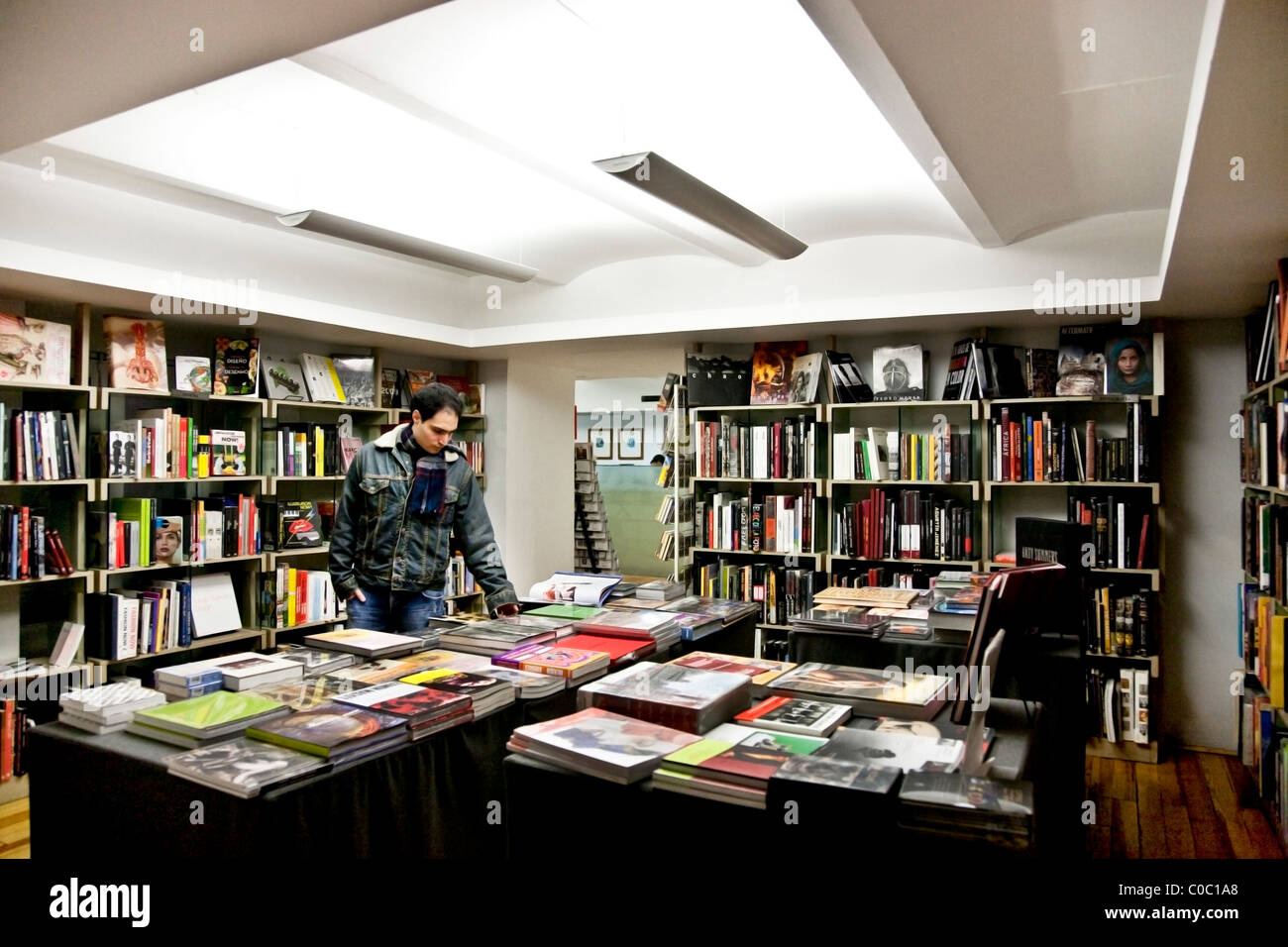 Ernst junger Mann in Jeansjacke durchsucht verschwenderischen Kunstbücher in gut sortierten gehobenen Buchhandlung Roma Stadtteil Mexiko-Stadt Stockfoto