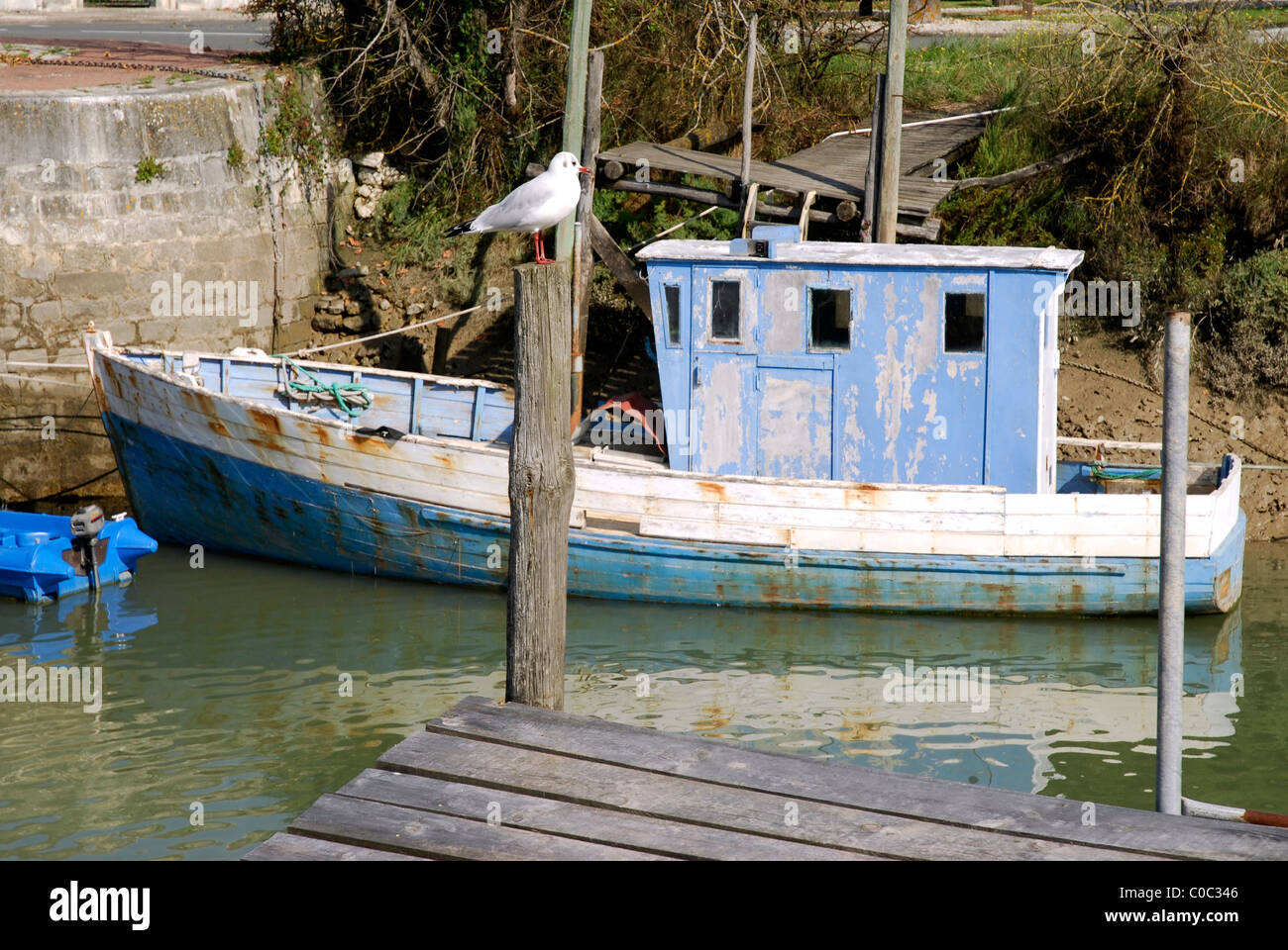 Altes Boot auf dem Wasser bei La Tremblade in Frankreich mit einer Möwe auf der post Stockfoto