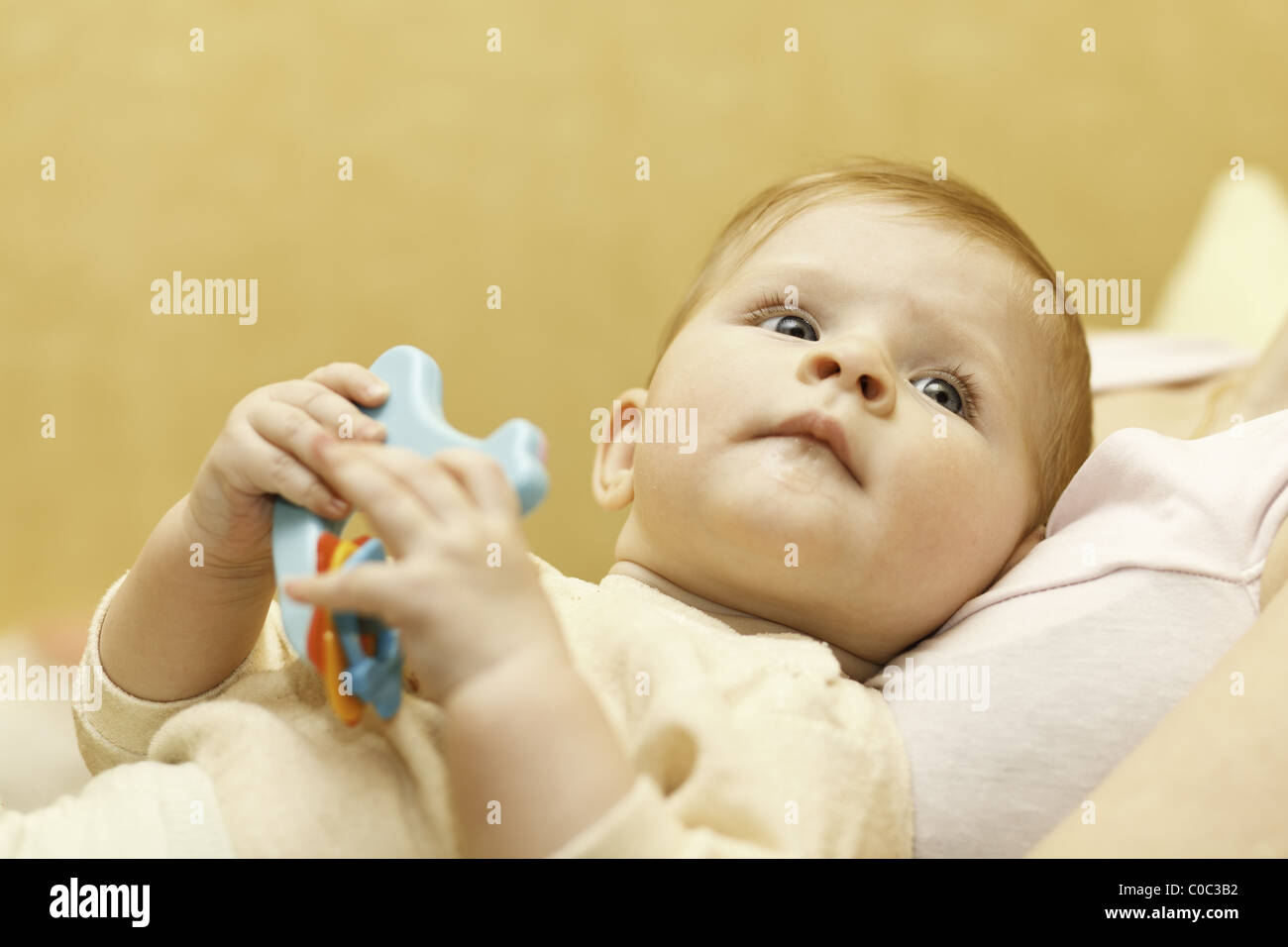 Baby mit Kunststoff-Spielzeug in der Hand. Stockfoto