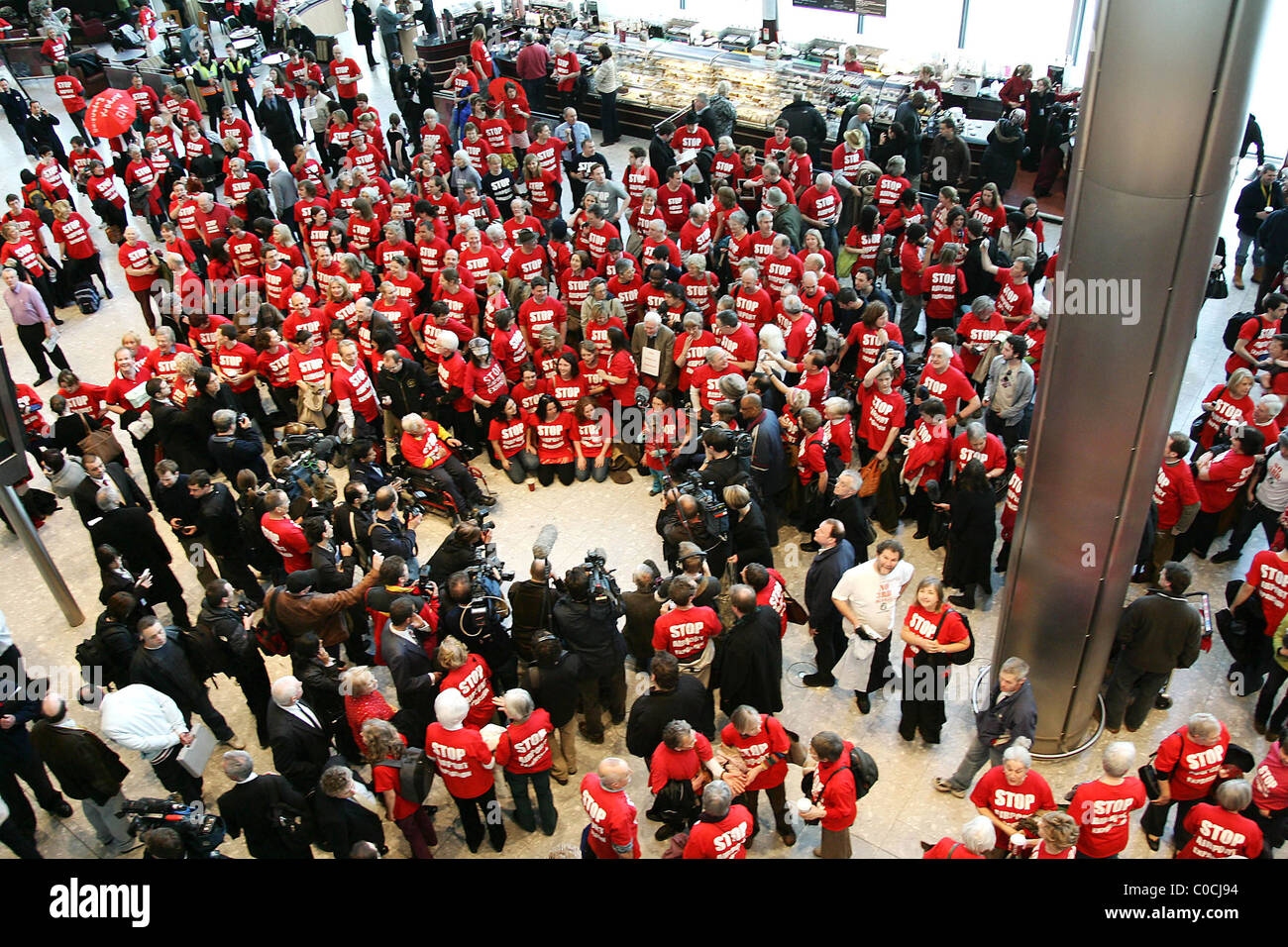 Eine große Gruppe von Demonstranten jeden Alters tragen rote T-shirts mit dem Slogan "Stop Flughafenausbau" konvergieren auf Heathrow Stockfoto