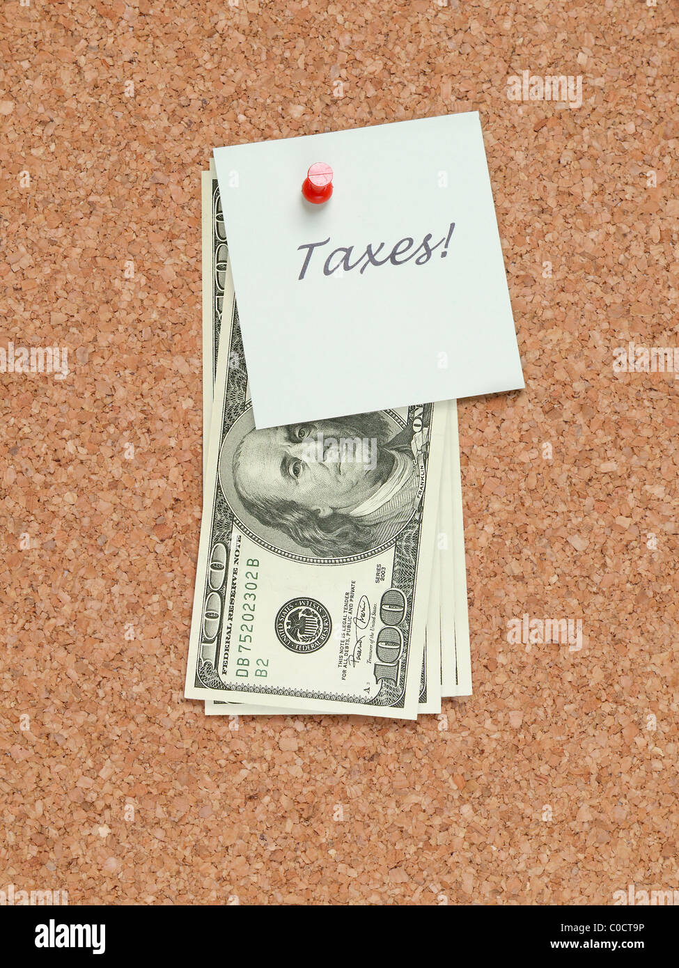 Papier-Memo-Schuldbrief mit Steuern Wort angebracht, Pinnwand mit Haufen von hundert-Dollar-Scheine Stockfoto