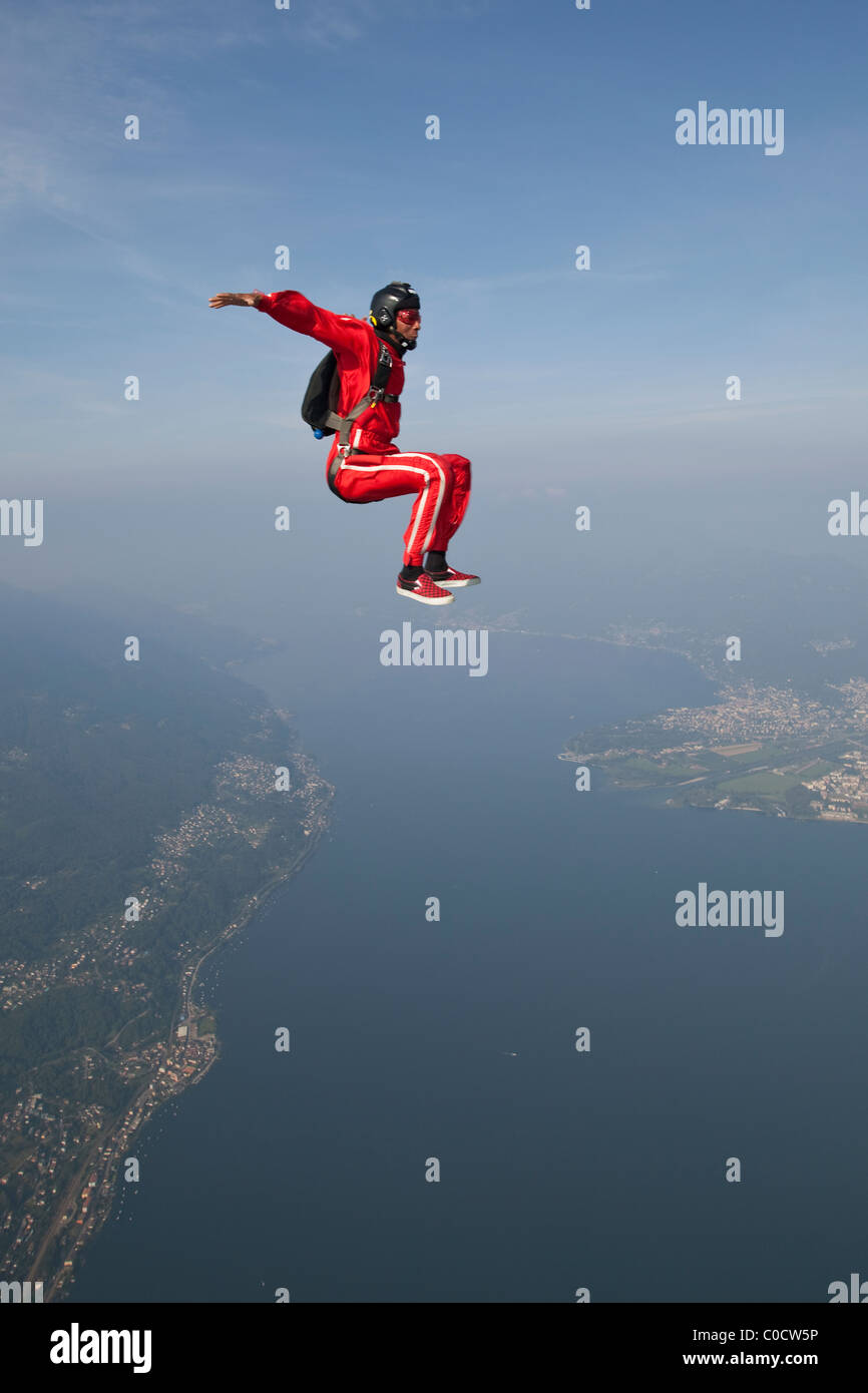 Fallschirmspringer ist sitzen mit einem Lächeln über einem See und schönen Landschaft fliegen. Stockfoto