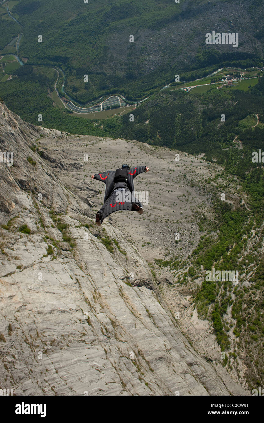 Base-Jumper in ein Wingsuit ist von einer Klippe und fliegt das Tal hinunter tauchen. Stockfoto