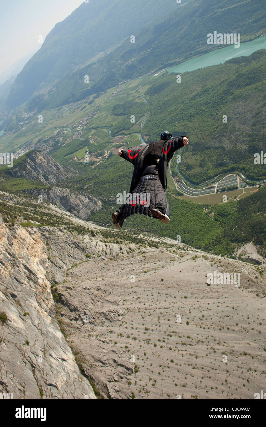 Base-Jumper in ein Wingsuit ist von einer Klippe und fliegt das Tal hinunter tauchen. Stockfoto