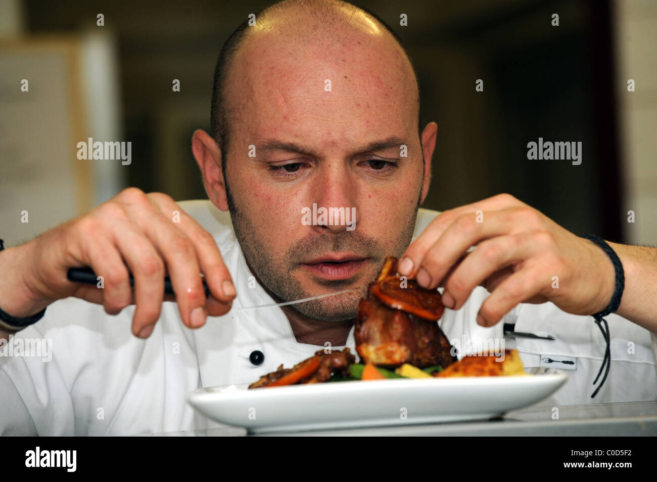 Chefkoch Alvaro Monter stellt den letzten Schliff auf eines seiner Gerichte auf dem pass Stockfoto