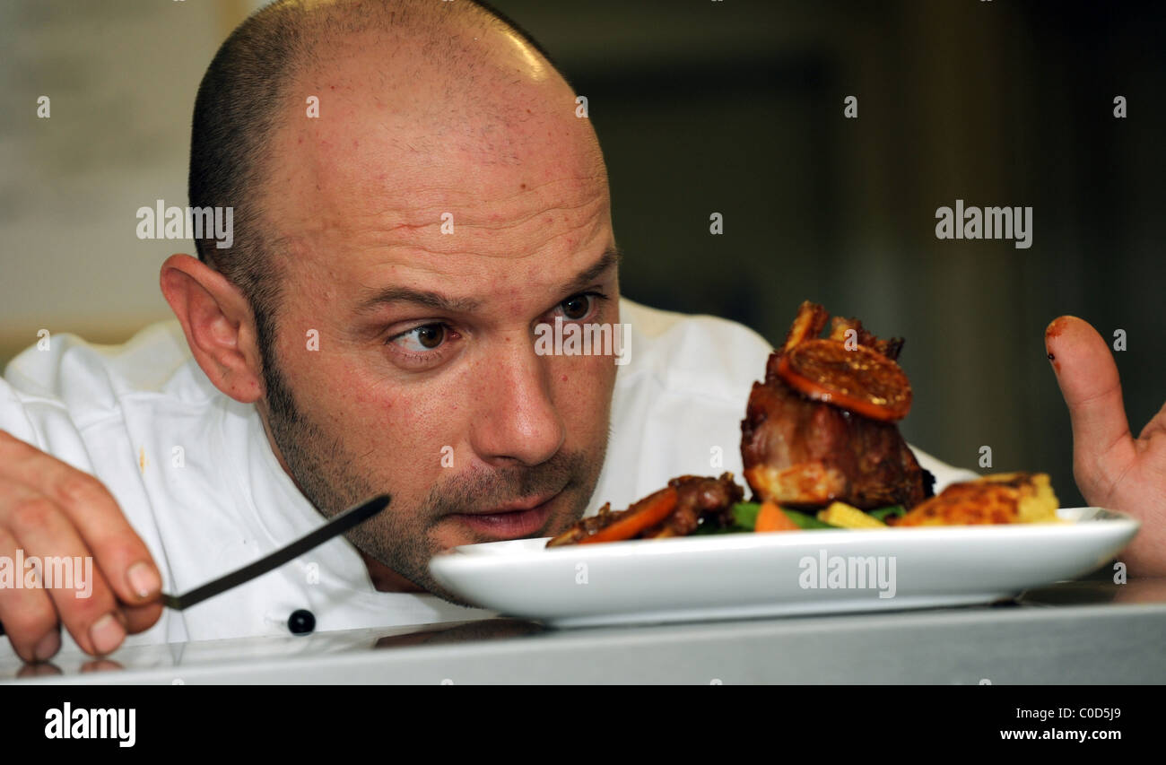 Chefkoch Alvaro Monter stellt den letzten Schliff auf eines seiner Gerichte auf dem pass Stockfoto