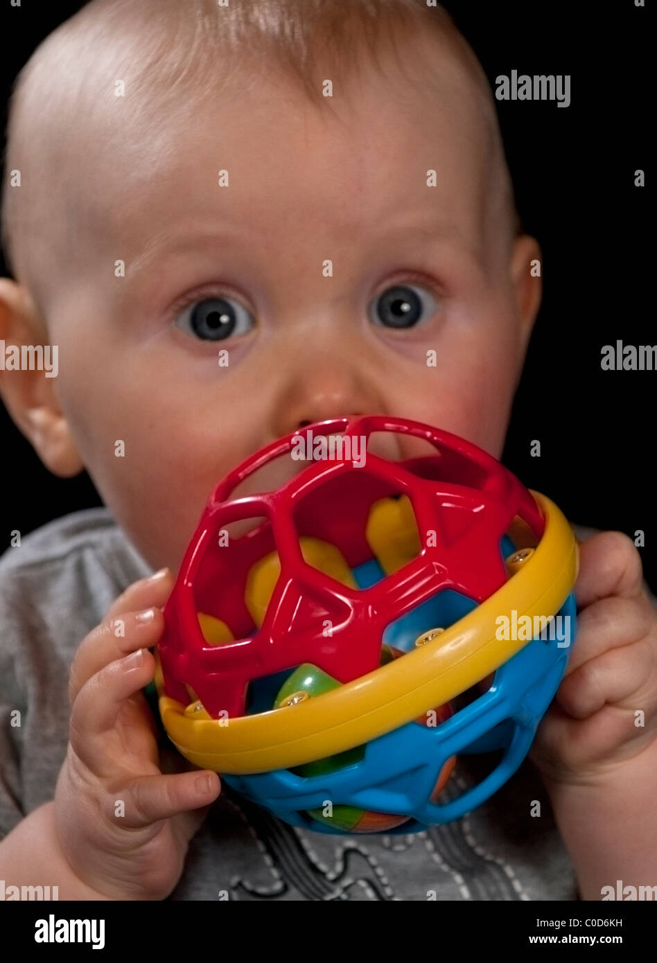 Baby Boy 8 Monate alt mit großen Augen und ein neues Spielzeug Stockfoto