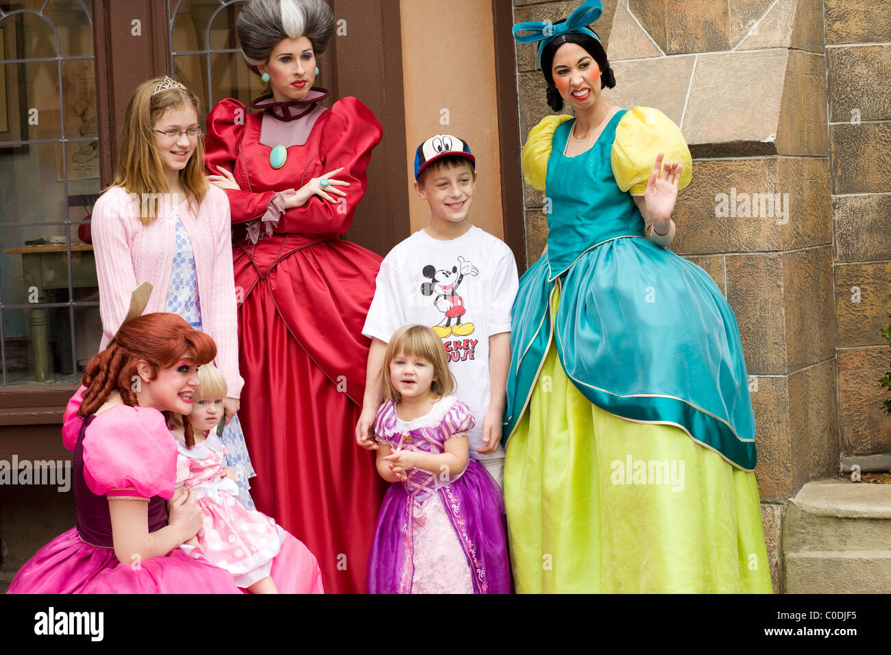 Cinderella 3 bösen Stiefschwestern posieren mit Kindern für ein Foto im Disney World Magic Kingdom. Stockfoto