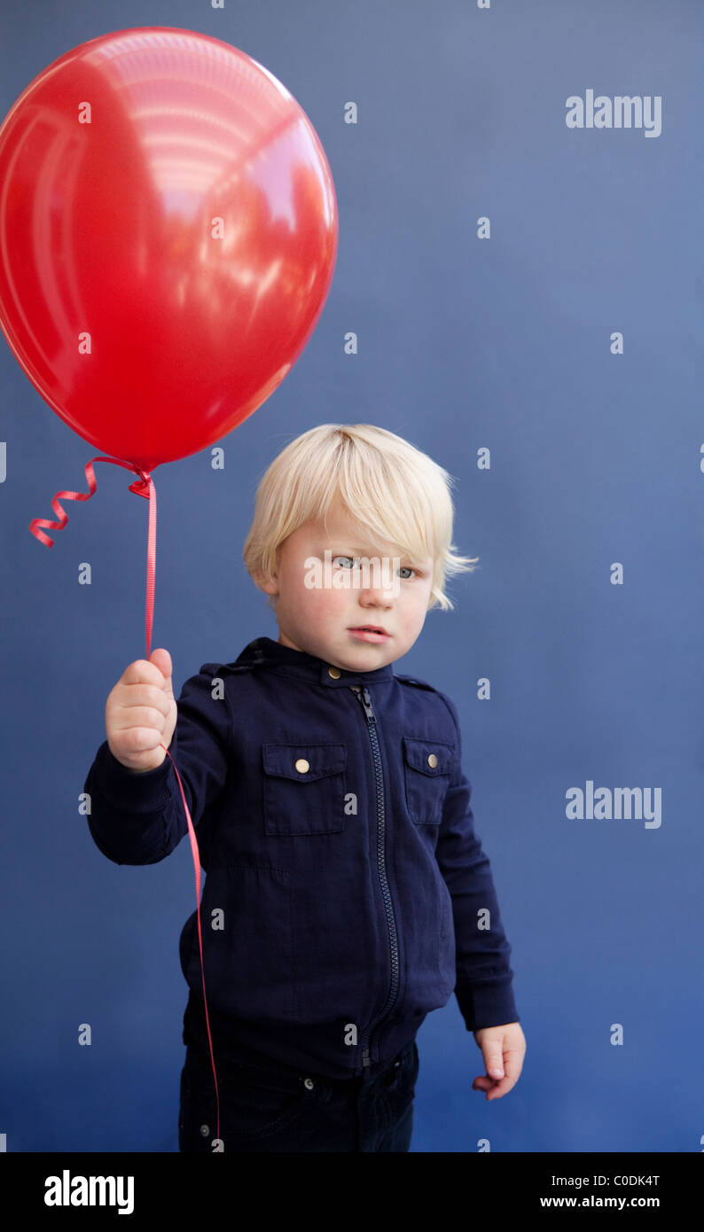 Kleinen Jungen Holding roten Ballon Stockfoto