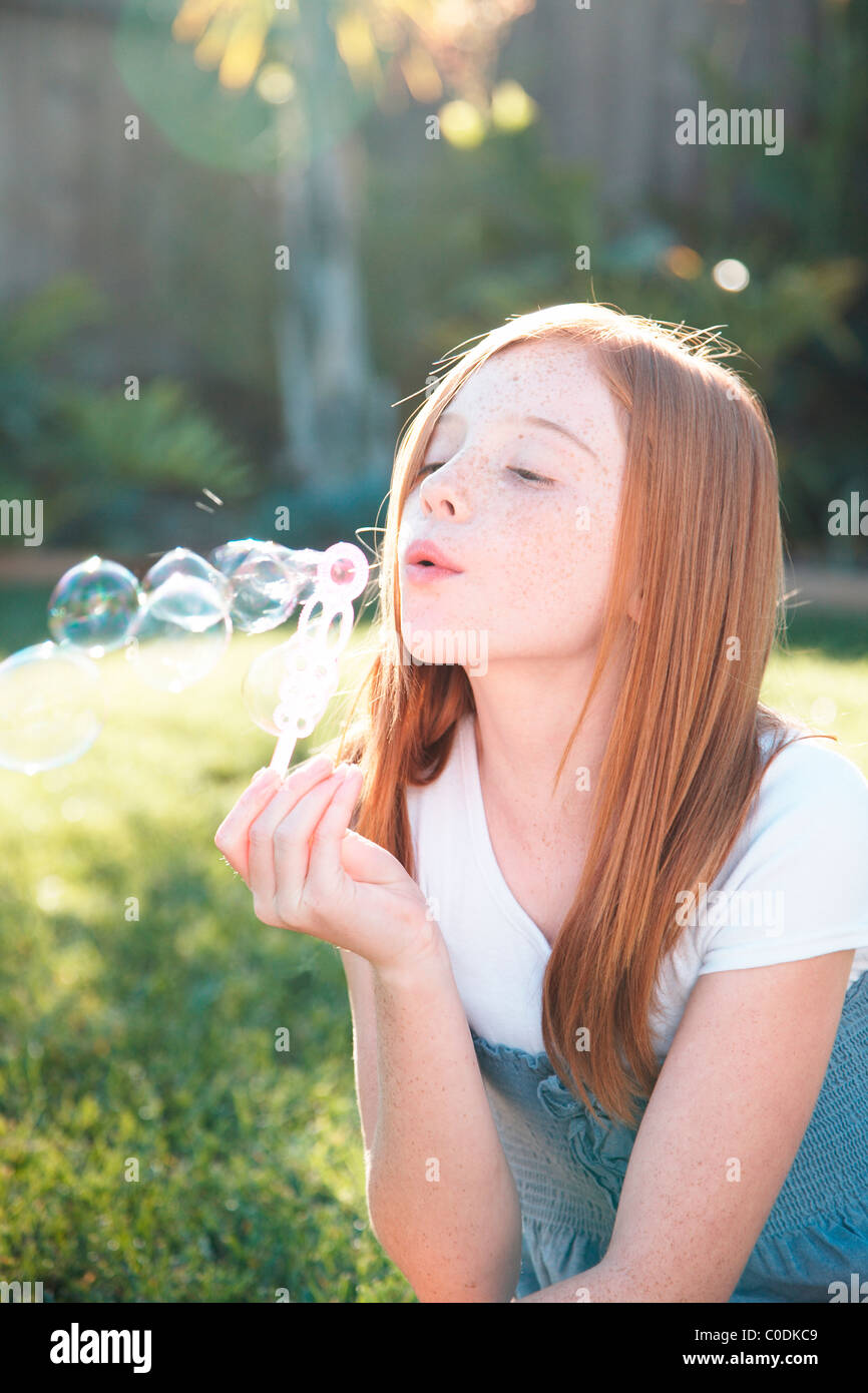 Mädchen bläst Luftblasen außerhalb Stockfoto