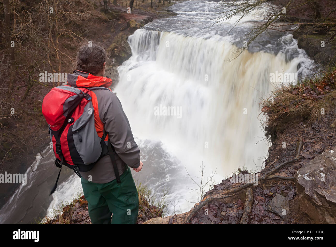Frau Walker in wasserdichte Kleidung an Sgwd Clun-Gwyn Wasserfall auf die Wasserfälle zu Fuß Powys Wales UK Stockfoto