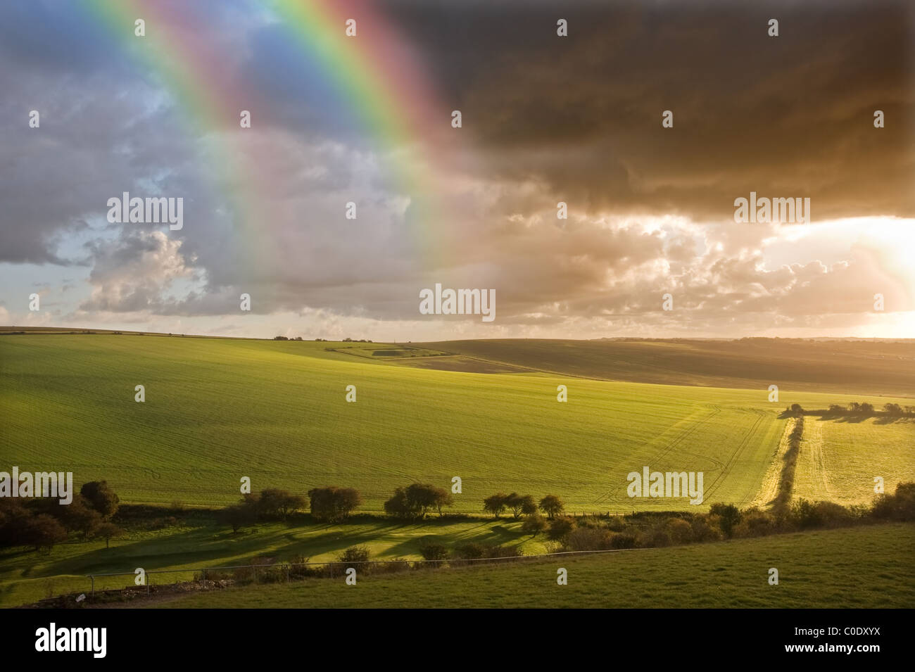 Schöner doppelter Regenbogen über dramatische Gewitterhimmel über englische landwirtschaftliche Landschaft Stockfoto