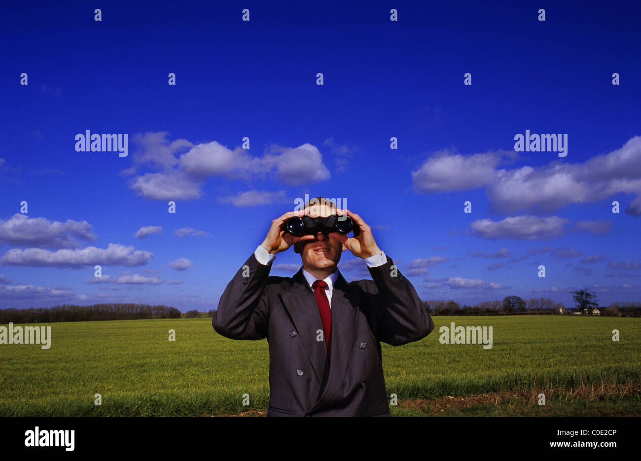 Unternehmer auf der Suche nach Wettbewerb durch ein Fernglas in der Landschaft Leeds Yorkshire UK Stockfoto