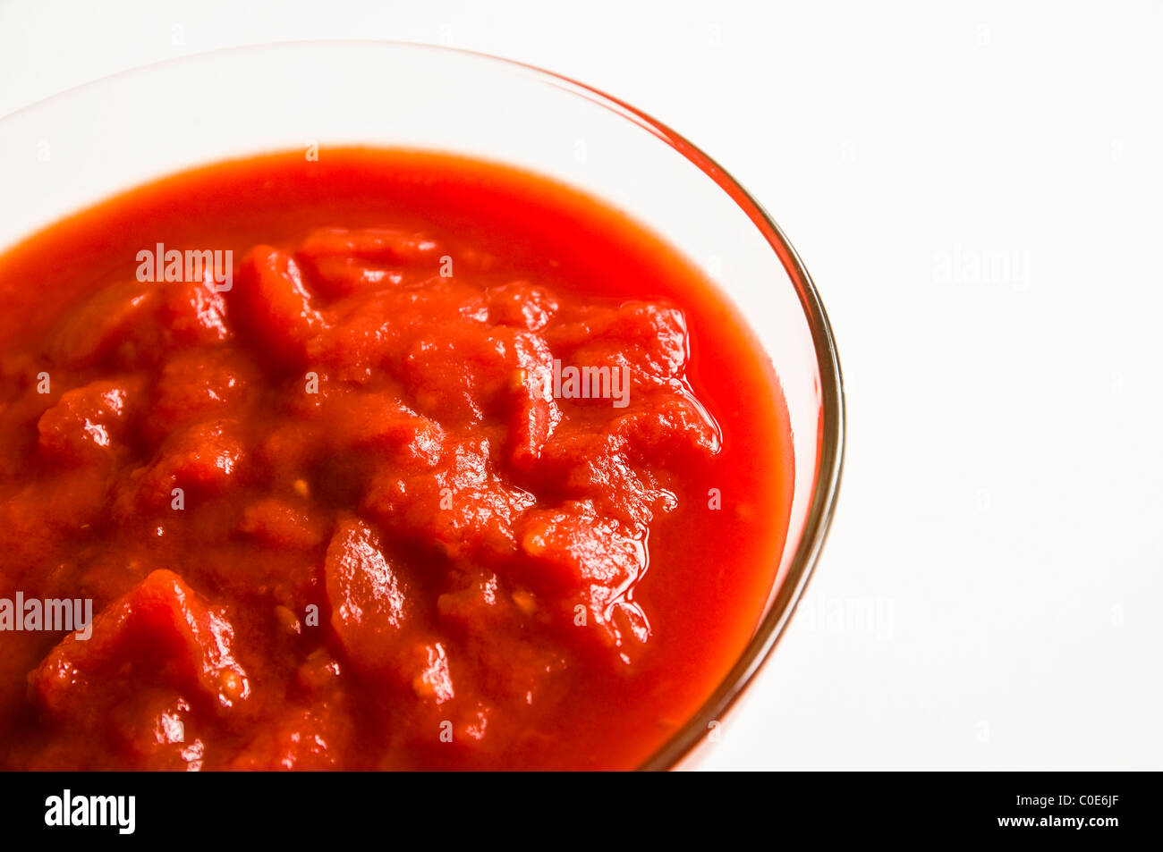 Gehackte (verzinnte) Tomaten in eine Glasschüssel. Stockfoto
