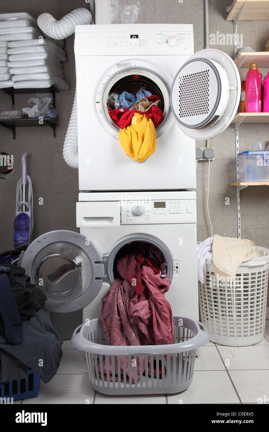 Körbe mit schmutziger Wäsche in die Waschküche mit Trockner und Waschmaschine Stockfoto