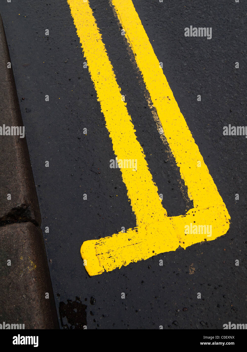 Straße, die Kennzeichnung einer frisch gestrichenen doppelten gelben Linie auf nasser Fahrbahn Stockfoto