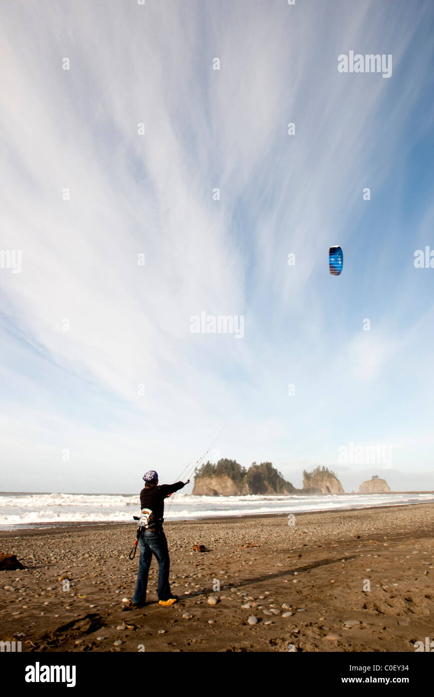Ein Mann, eine blaue Drachen entlang der Küste von Washington. Meer-Stacks und dem Pazifischen Ozean in der Ferne. Stockfoto