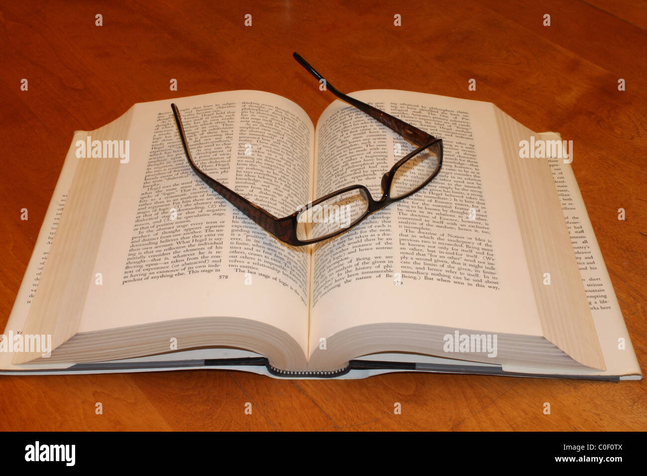 Aufgeschlagene Buch und die Gläser auf Holztisch Stockfoto