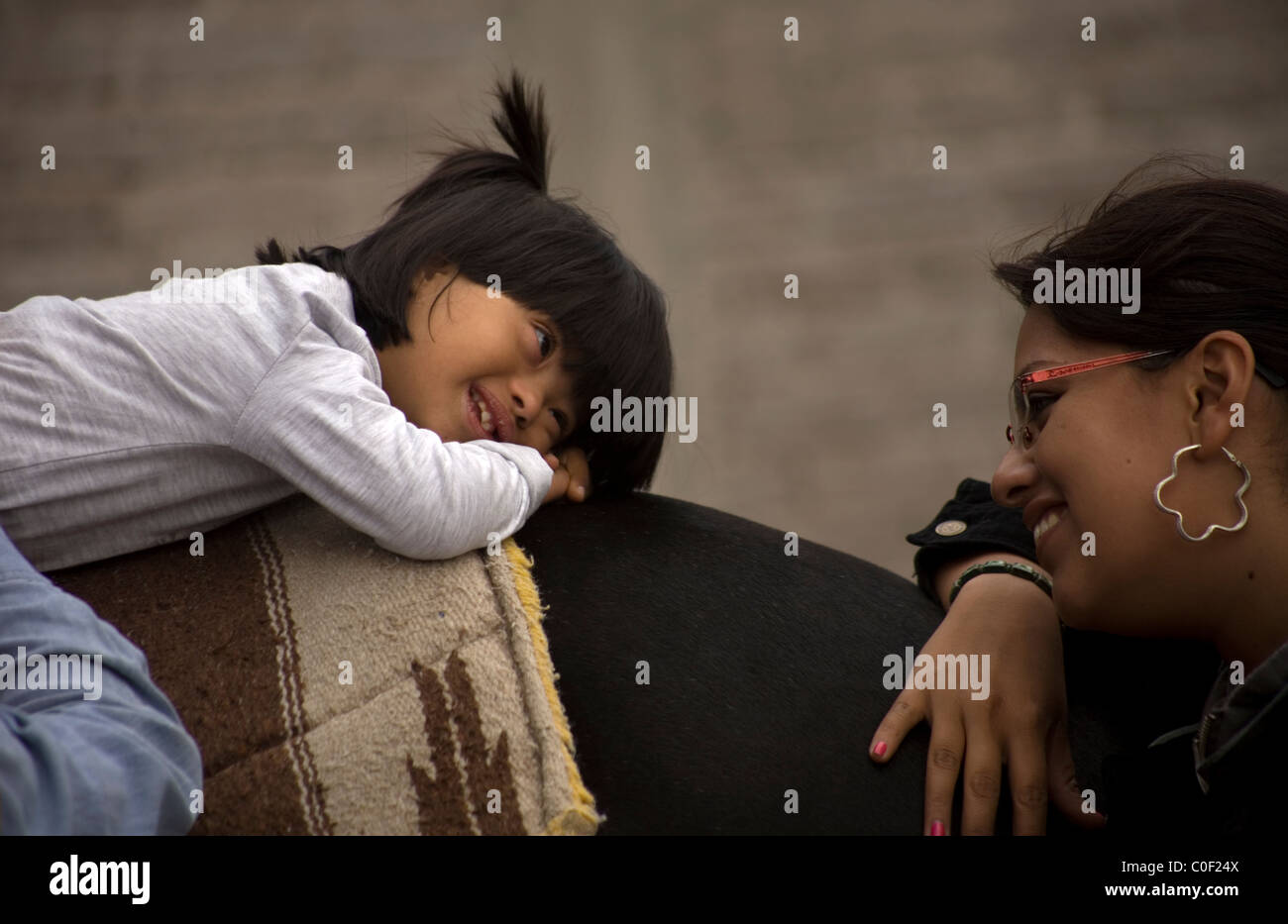 Ein Mädchen, das Down-Syndrom und infantile zerebrale Lähmung infolge eines Schlaganfalls hat lächelt ihr Kursleiter, wie sie auf t ruht Stockfoto