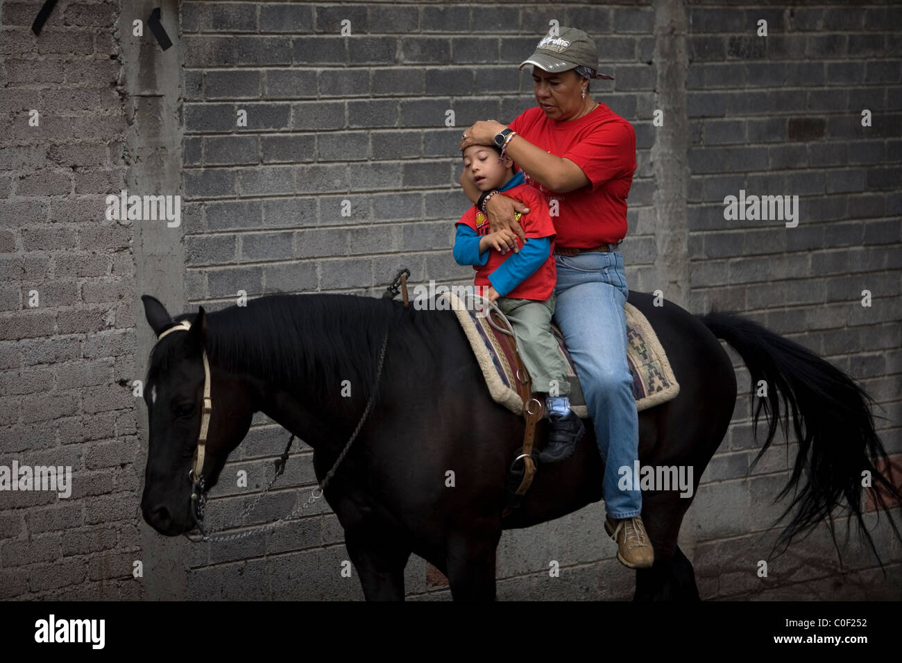 Equine Therapeut Guadalupe Pena behandelt einen jungen, der infantilen zerebralen Lähmung bei seinem Pferd-Therapie-Sitzung in Mexiko Cit hat Stockfoto